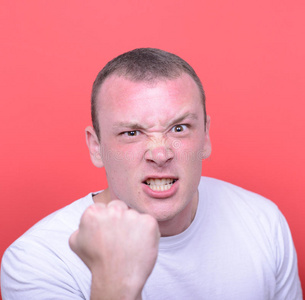 愤怒的男人尖叫的画像在红色背景下露出拳头