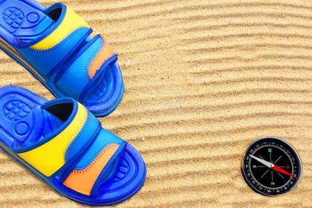 沙滩上的拖鞋和指南针。
