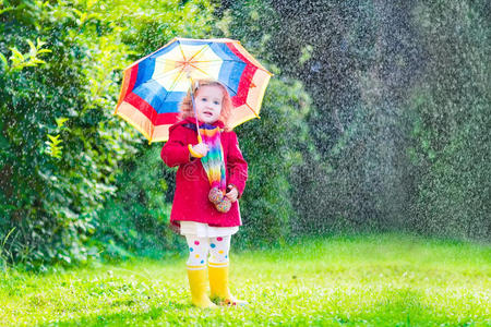 可爱的小女孩在雨中玩耍