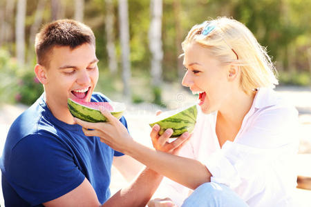在海滩吃西瓜的幸福夫妻
