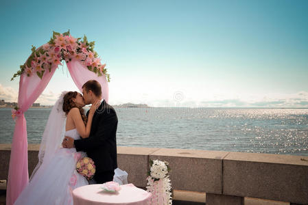 新婚夫妇在海岸线附近接吻