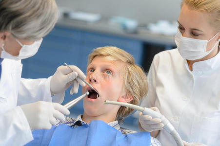 牙科医生和助手与害怕的青少年病人