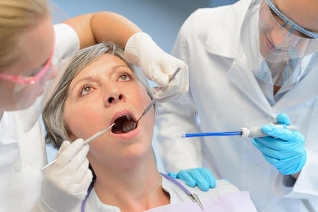 牙科检查老年女性患者牙医团队