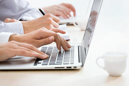商务女性在笔记本电脑键盘上打字