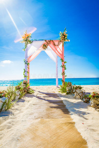 户外热带沙滩上用鲜花装饰的结婚拱门