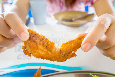 在泰国餐馆吃鸡翅的女人。