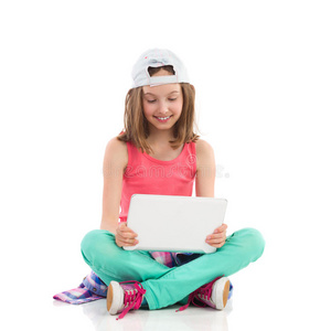 戴棒球帽的女孩用数字平板电脑