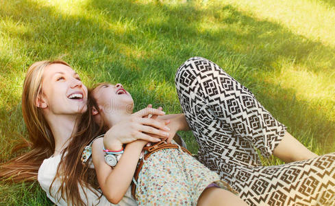 阳光明媚的小女孩和妈妈在草地上玩得开心