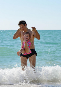 父亲和蹒跚学步的小女孩在海上