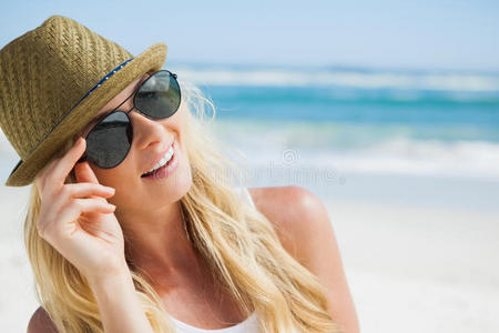 时髦的金发女郎在沙滩上微笑