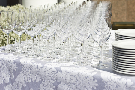 婚礼上，白色的丝绸桌布，在大街上的眼镜。阳光明媚的天气。婚礼的筹备工作