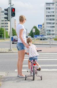 母亲和女儿用自行车斑马线上