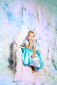 在冬天的仙子的背景上的公主裙的小女孩