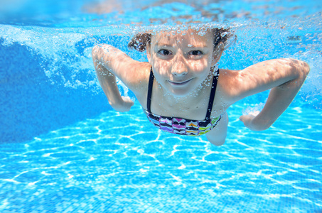 快乐积极的水下孩子在游泳池里游泳