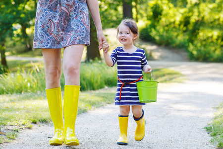 母亲和小孩子可爱的黄色橡胶靴