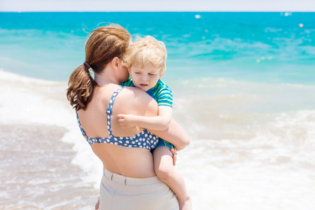 母亲和她的小儿子在海滩上的肖像