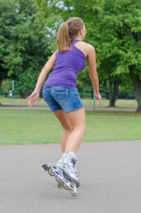 女人滑冰旱冰鞋在公园里