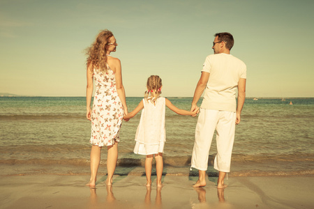 快乐家庭站在海滩在白天的时间