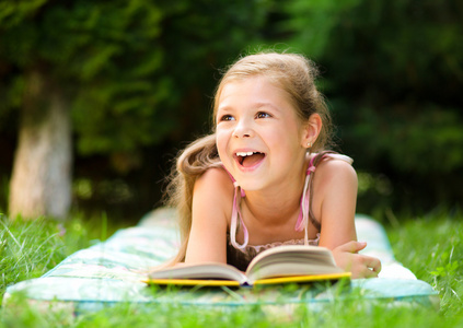 小女孩读一本书户外
