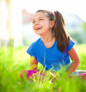 一个小姑娘坐在绿草地上的肖像
