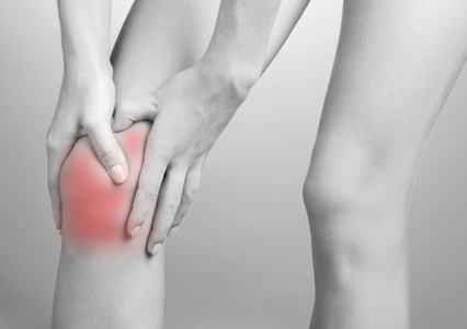 疼痛的概念。女人抱着膝盖疼痛深浅不一的灰色
