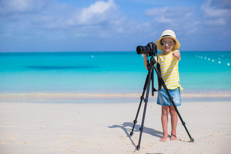 她暑假期间在三脚架上的相机拍摄的小女孩