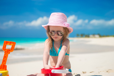 在加勒比海度假期间玩沙滩玩具的小女孩