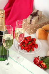 用香槟，草莓和房间里的玫瑰的浪漫静物画。