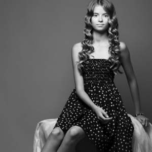现代蒙娜莉萨的概念。黑色连衣裙坐在漂亮的女孩