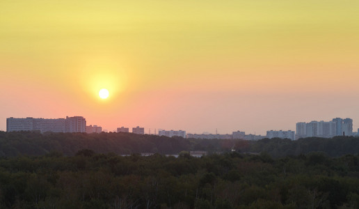 日出时黄色天空中的太阳在城市上空