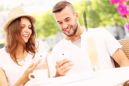 幸福的夫妇与他们的智能手机，在一家咖啡馆