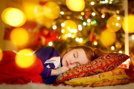 女孩睡在圣诞树下