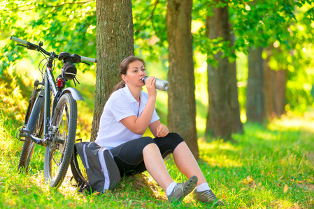 瓶水附近一棵树上休息的年轻女子