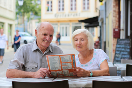 可爱的年长夫妇在户外街边咖啡馆休息