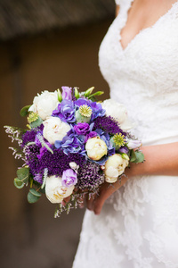 美丽的新娘在带一束鲜花的白连衣裙