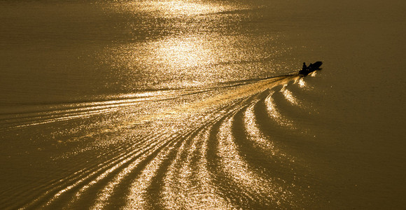 小船穿过一条金色的河流图片