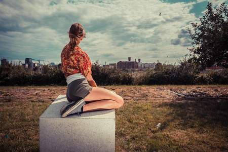 年轻女子坐在外面，看着城市