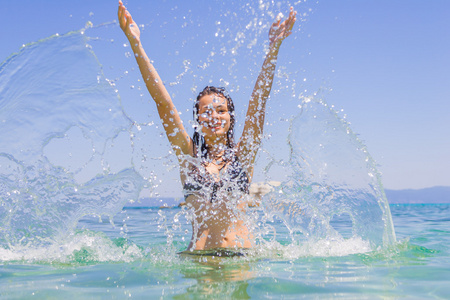 年轻女子在海上泼水