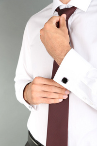 男人做领扣，在灰色的背景上