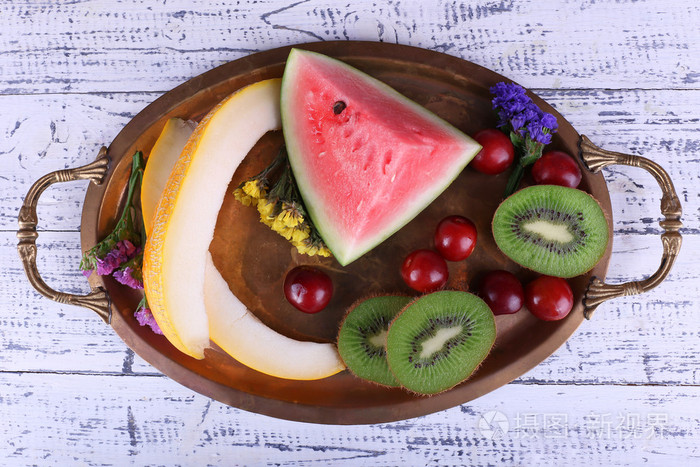 片的西瓜猕猴桃西瓜木制背景上的金属托盘上