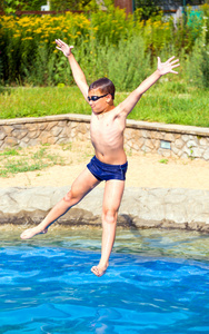 男孩跳进游泳池