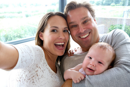 幸福的夫妇带婴儿的自拍照