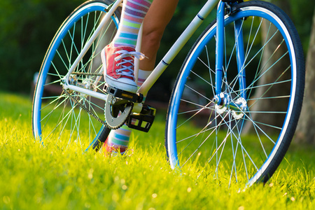 时髦的自行车，在 colorfus 袜子的女人