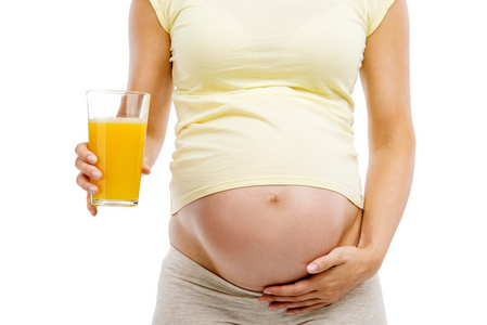 怀孕的女人控股桔子汁