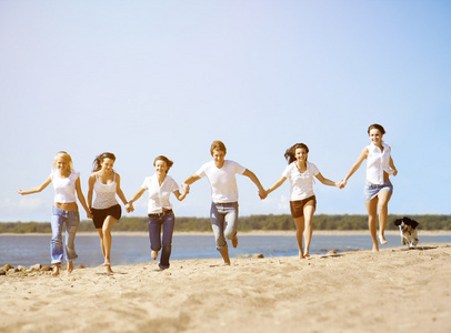 组年轻的朋友在度假享受海滩派对。人 h
