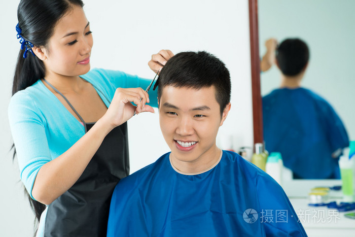 女理发师剪头发的男性客户端