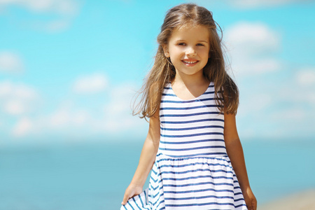 夏天肖像在海滩上的衣服的小女孩