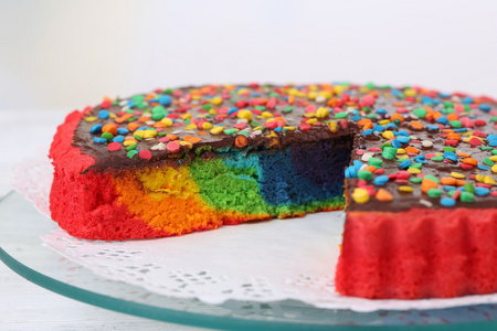 美味的彩虹蛋糕放盘子里，在桌子上，在明亮的背景上