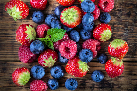 木制的背景或表上的浆果。蓝莓 树莓 草莓 森林水果