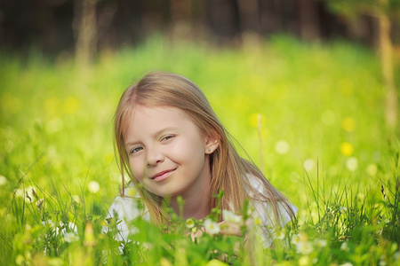 草丛中的小女孩美丽的年轻女子站在田野, 绿草和花朵.户外享受大自然.
